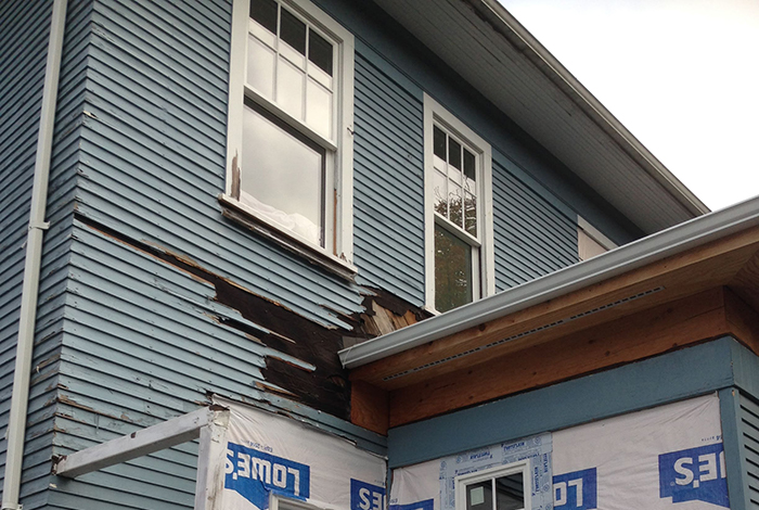 Image of damaged siding. Look for cracks, holes, and damage in your siding when preparing for winter