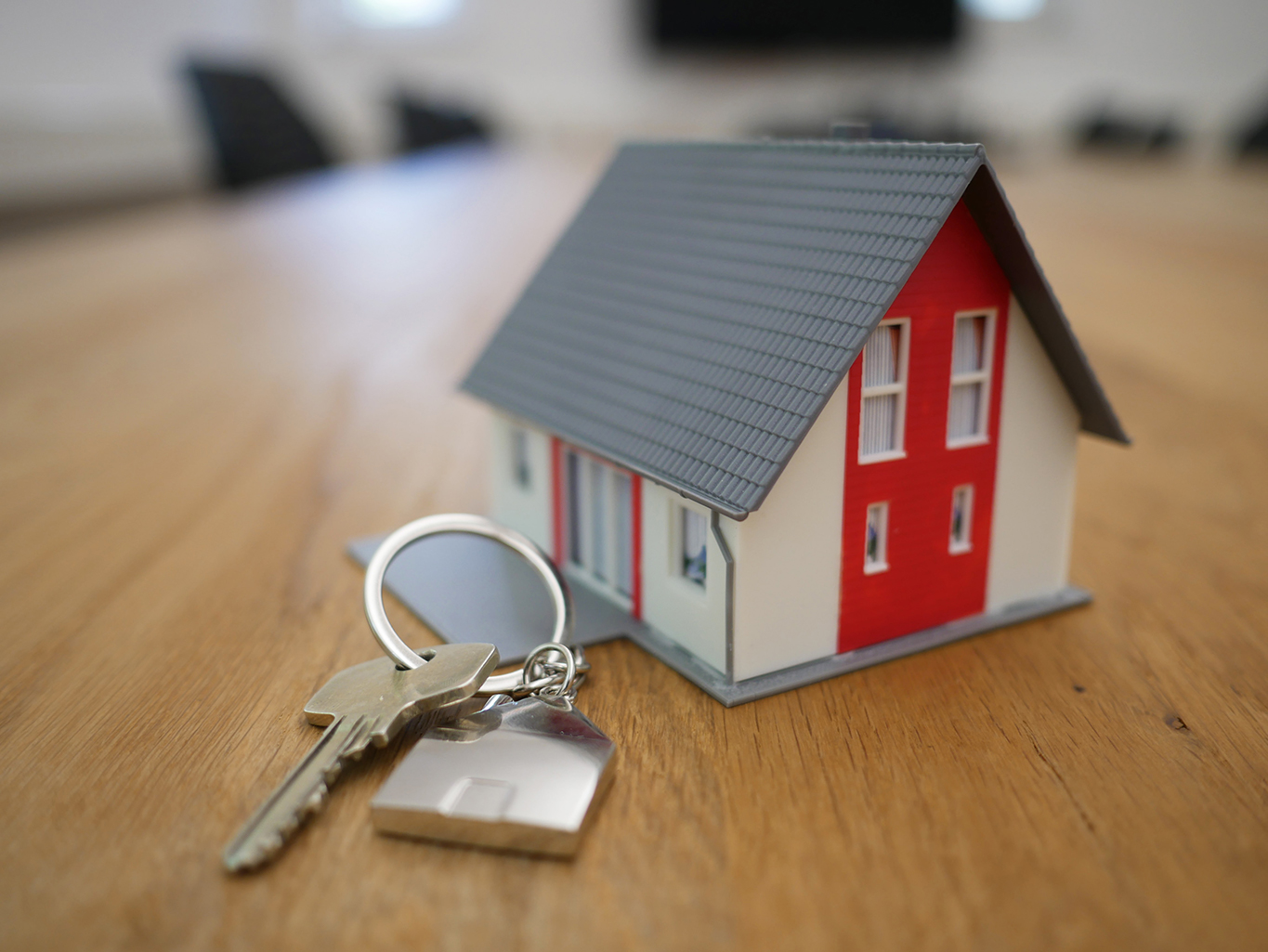 A picture of a keys on a keychain in the shape of a house